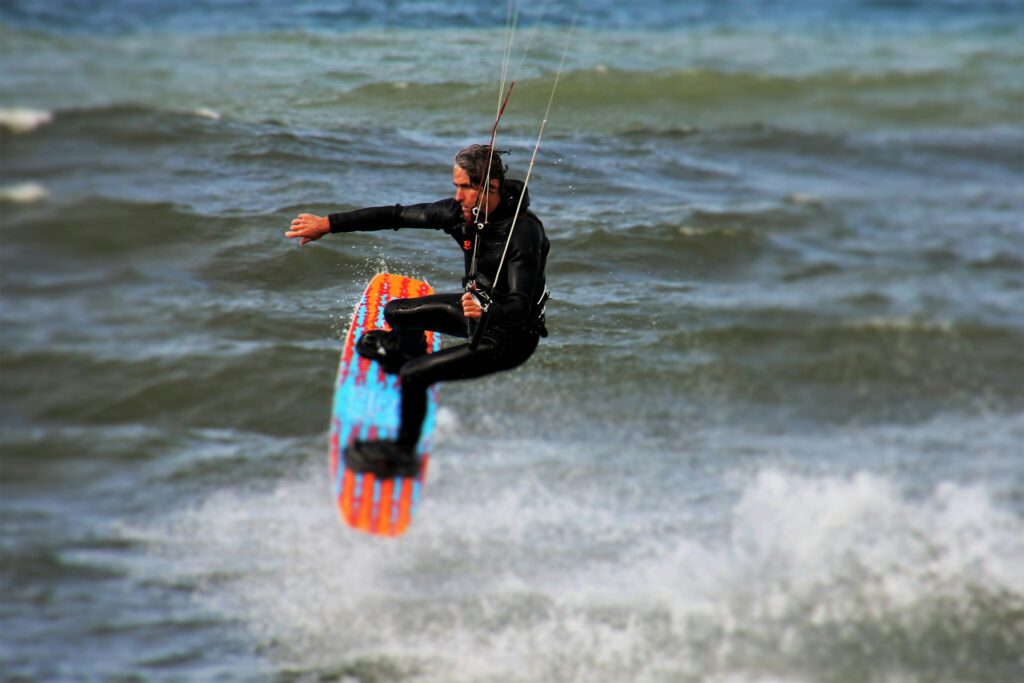 A kitesurfing student practicing body dragging in the shallow waters of Paje Beach, Zanzibar, under the guidance of an instructor.